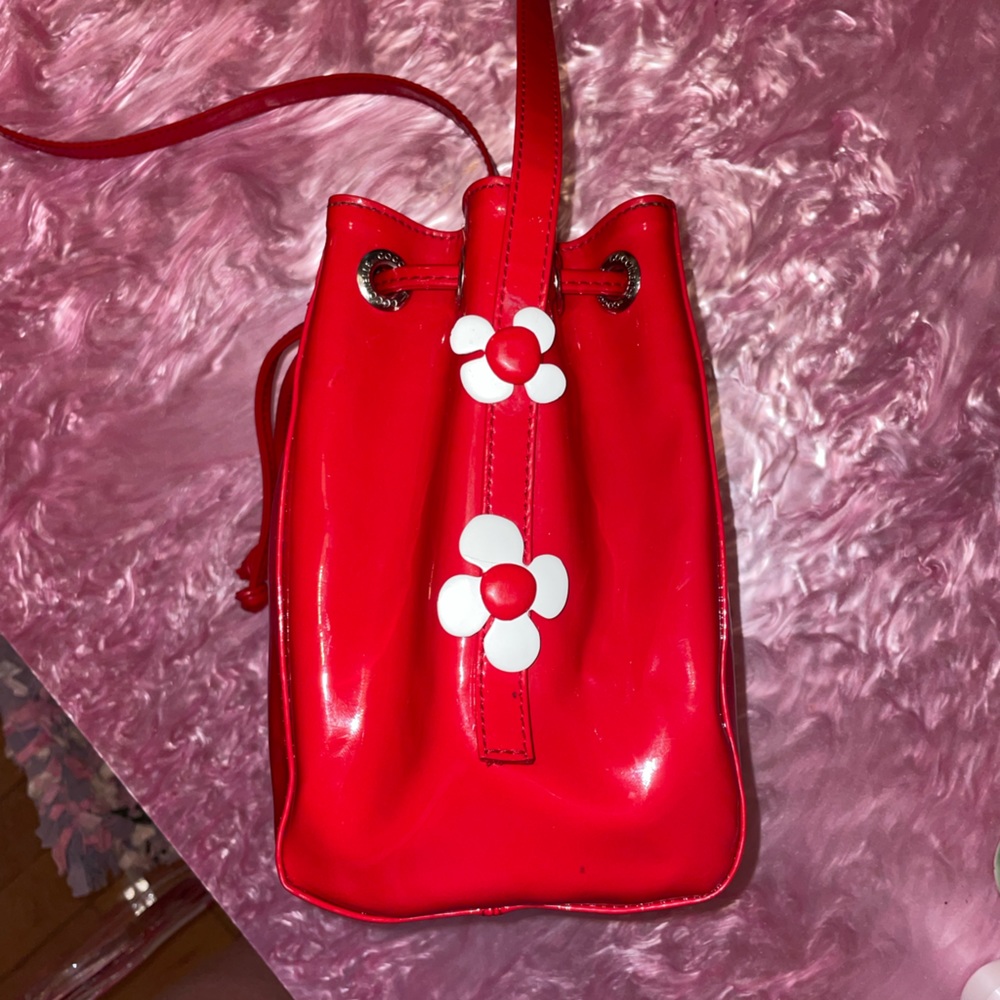 coccinelle red patent bucket bag with enamel daisies
